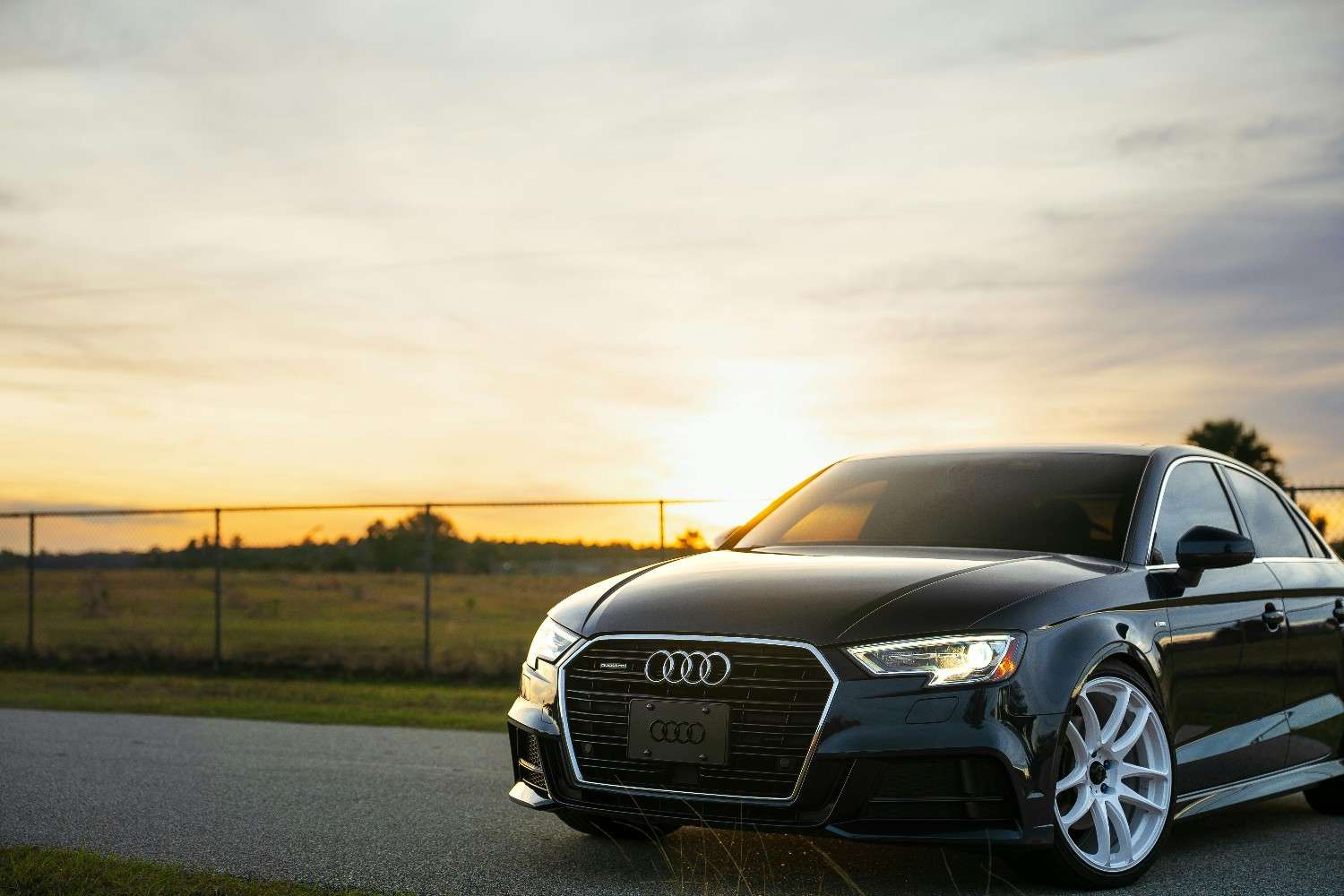 A modern car driving through a clean highway during sunset, symbolizing safety and freedom